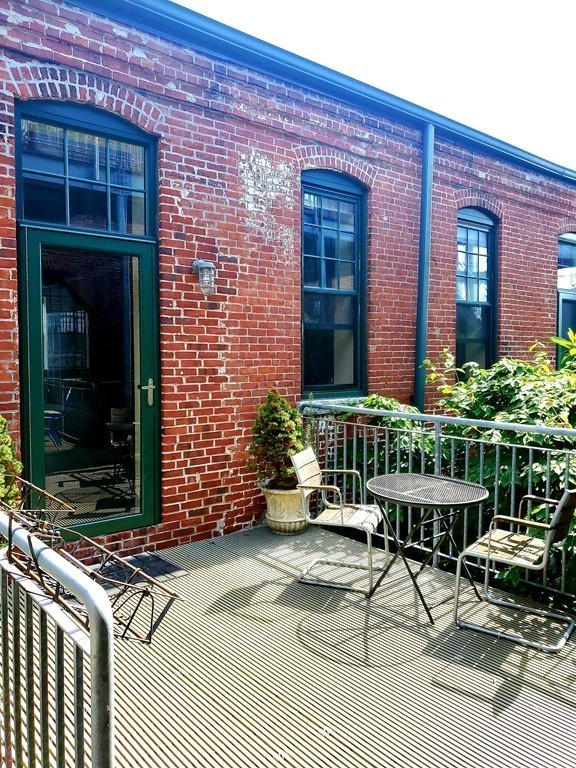 60 Dudley Street, Unit 22 Chelsea, MA 02150 - Photo 3 of 15 a building with table and chairs in front of it