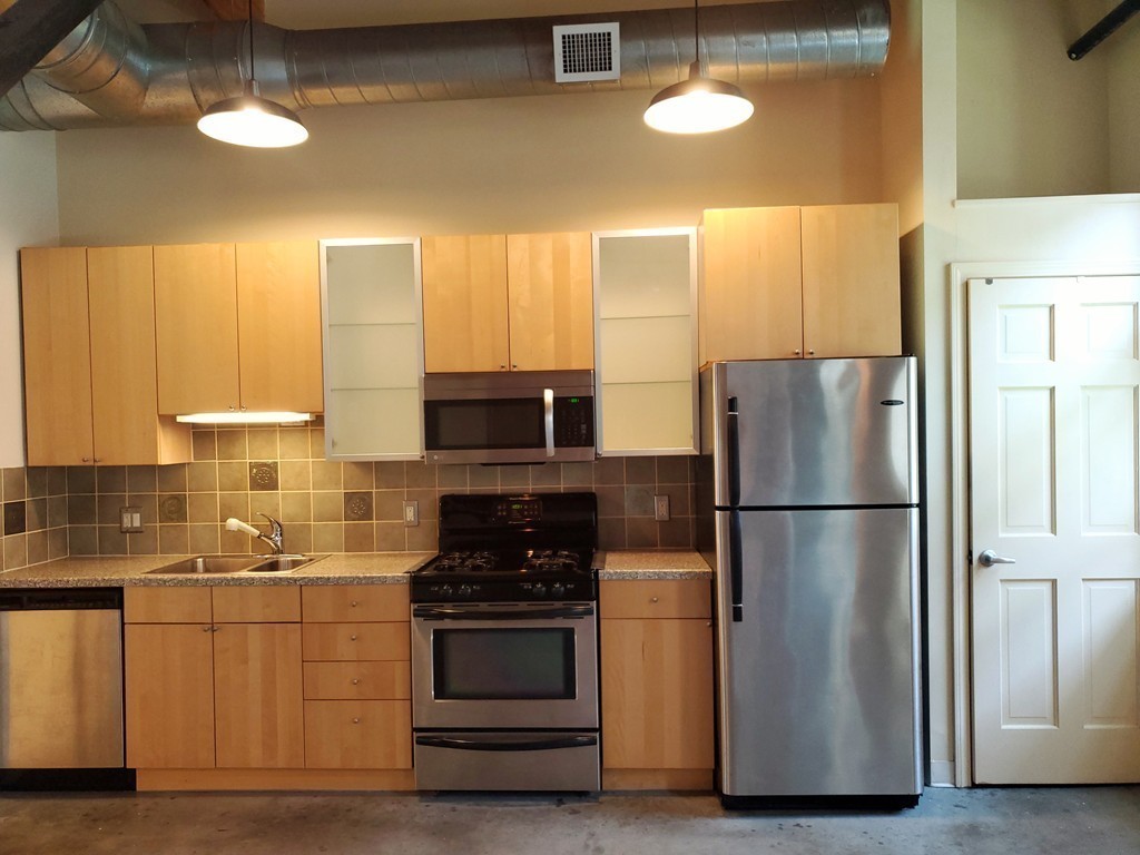 60 Dudley Street, Unit 22 Chelsea, MA 02150 - Photo 5 of 15 a kitchen with a refrigerator and a stove top oven