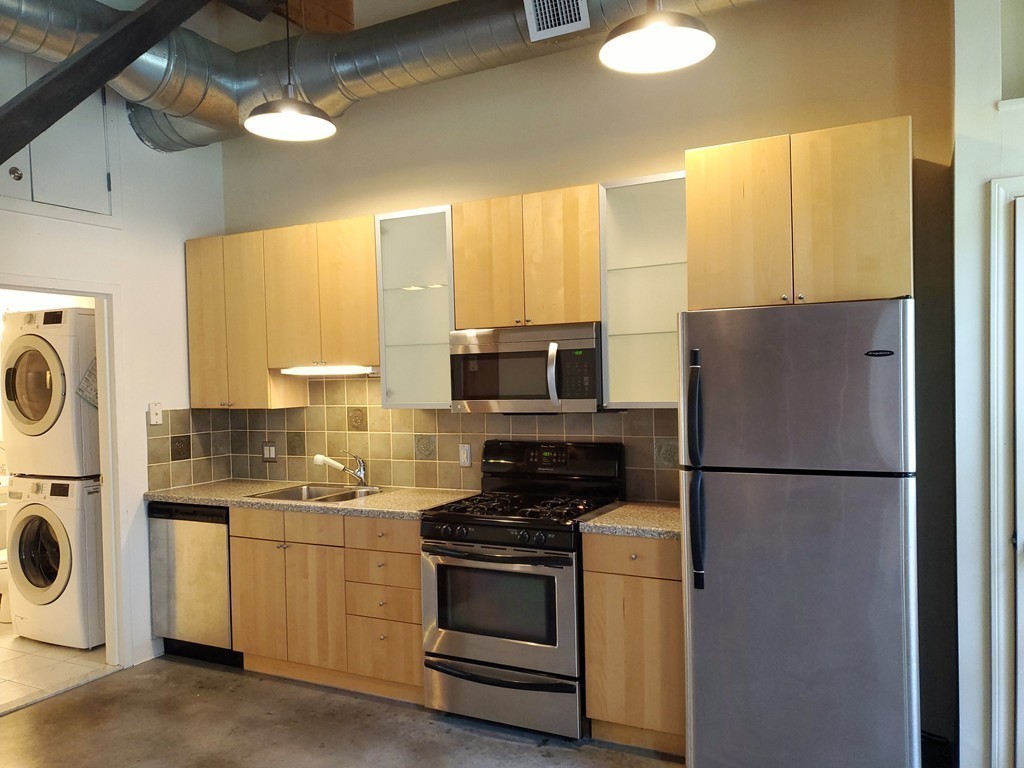 60 Dudley Street, Unit 22 Chelsea, MA 02150 - Photo 6 of 15 a kitchen with a refrigerator a stove top oven a sink and dishwasher