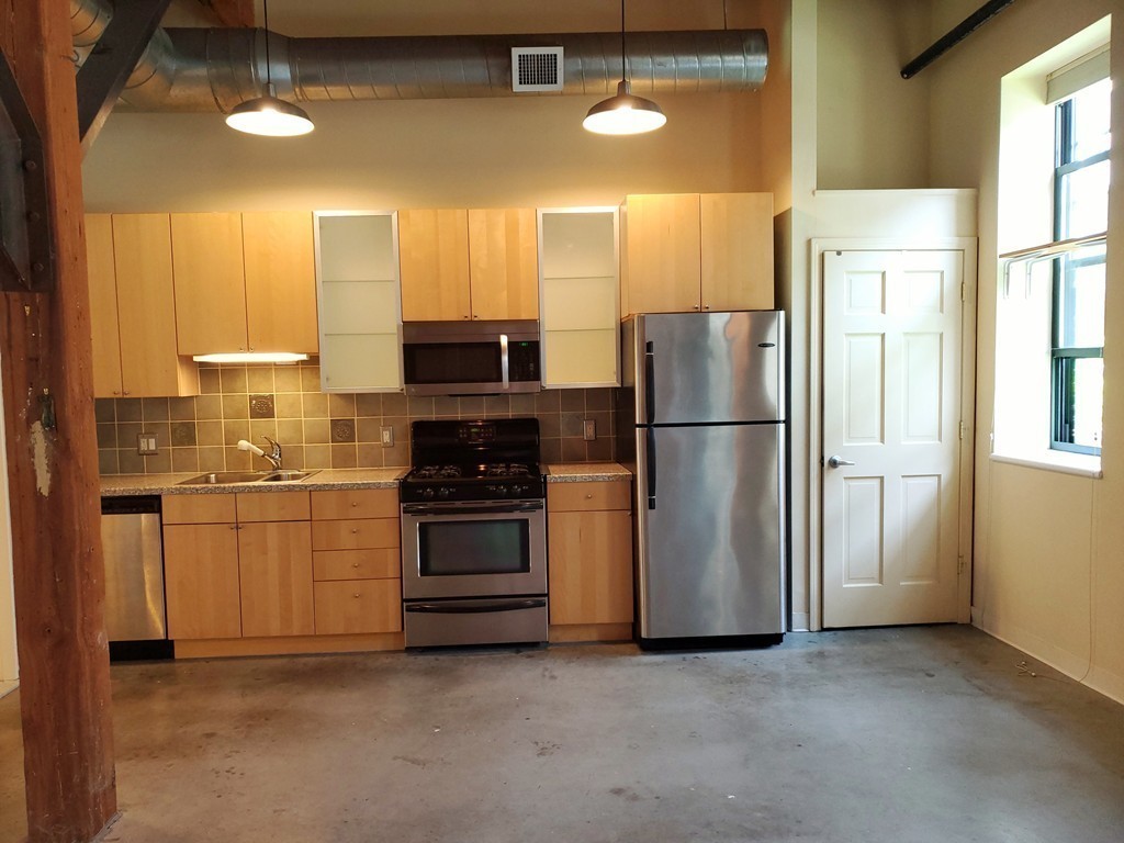 60 Dudley Street, Unit 22 Chelsea, MA 02150 - Photo 7 of 15 a kitchen with stainless steel appliances a refrigerator sink and stove