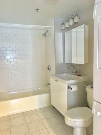 60 Dudley Street, Unit 22 Chelsea, MA 02150 - Photo 10 of 15 a bathroom with a granite countertop sink a toilet a mirror and bathtub