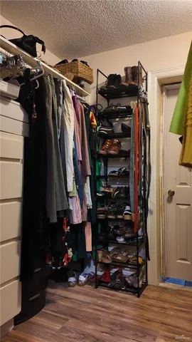 a view of walk in closet with clothes and shoes