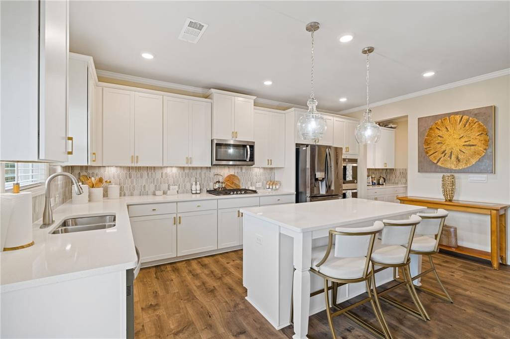 304 Ellenton Place Canton, GA 30115 - Photo 2 of 76 a kitchen with stainless steel appliances granite countertop a table chairs sink and cabinets