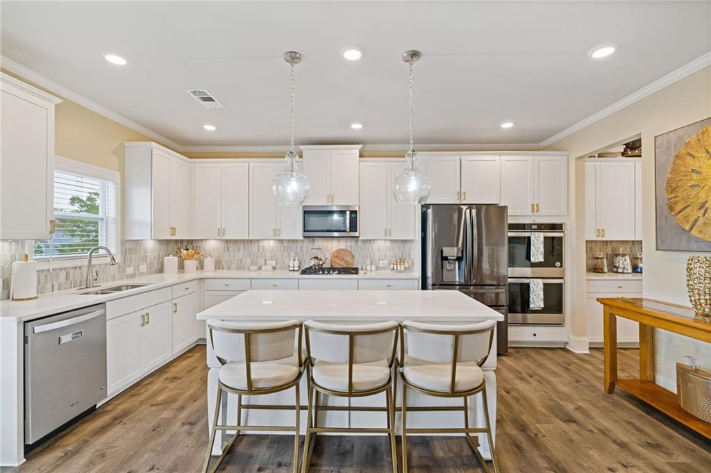 304 Ellenton Place Canton, GA 30115 - Photo 27 of 76 a kitchen with stainless steel appliances granite countertop a table chairs sink refrigerator and microwave