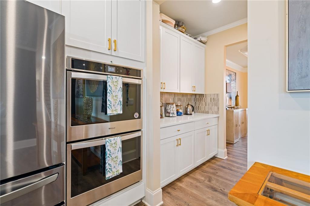 304 Ellenton Place Canton, GA 30115 - Photo 32 of 76 a kitchen with stainless steel appliances white cabinets and wooden floors