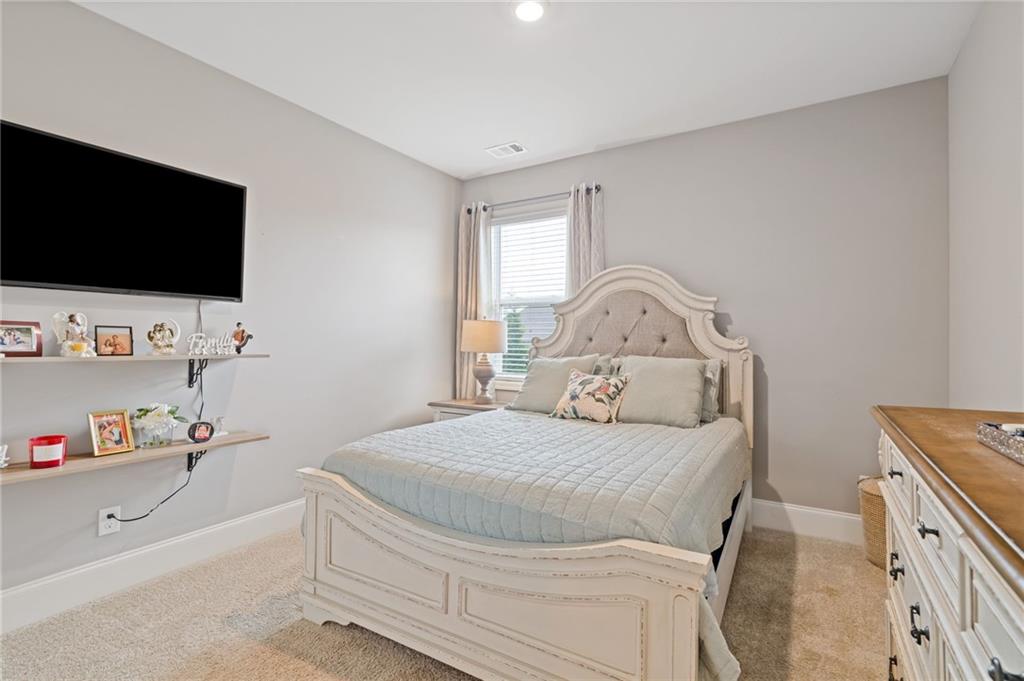 304 Ellenton Place Canton, GA 30115 - Photo 34 of 76 a bedroom with a bed and flat tv screen on the dresser