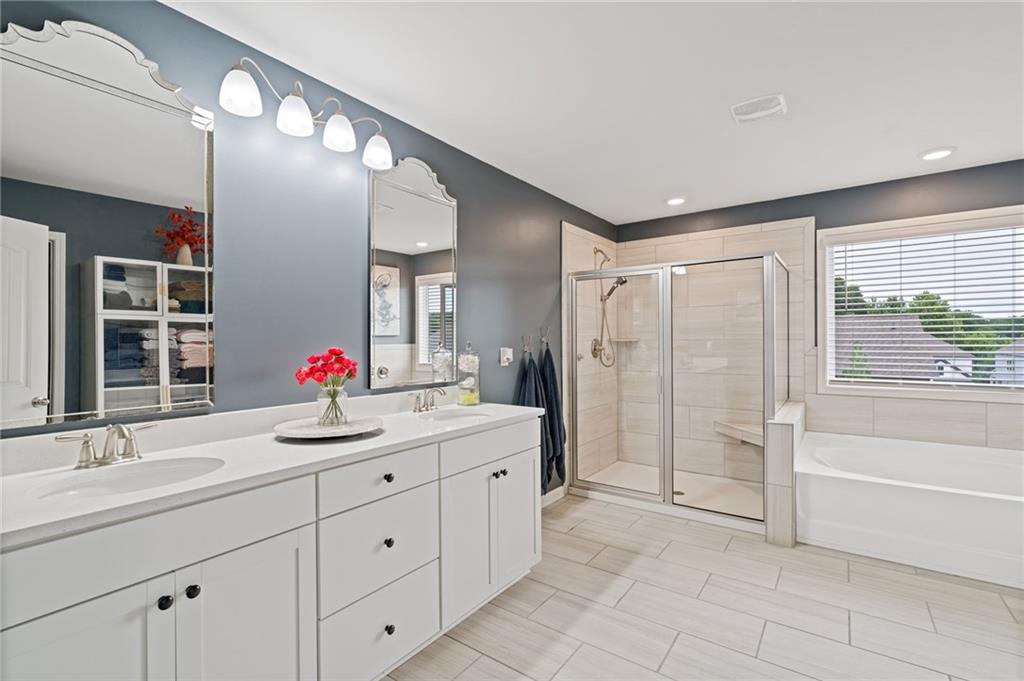 304 Ellenton Place Canton, GA 30115 - Photo 50 of 76 a spacious bathroom with a granite countertop sink mirror and shower