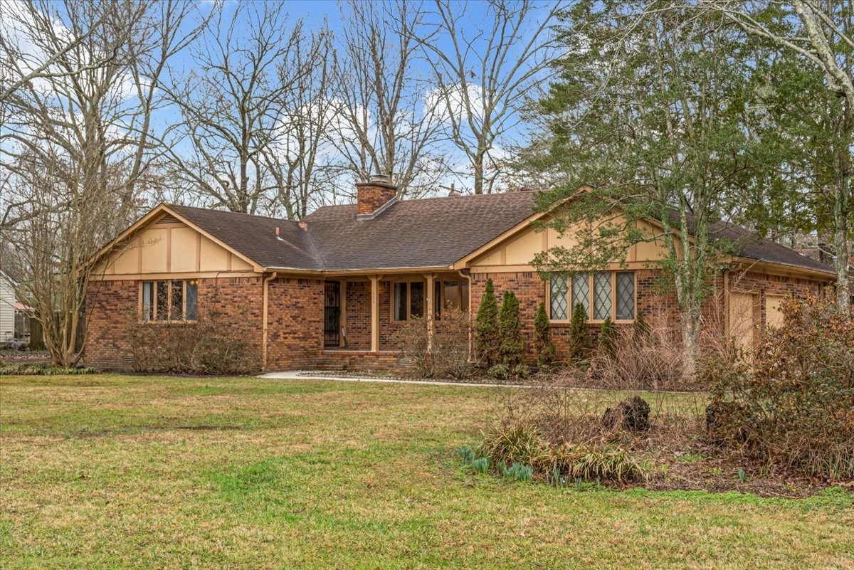 a front view of house with yard and trees around