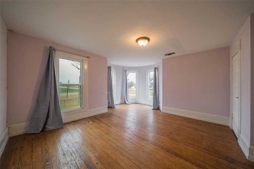 101 South Jacob Lane Winters, TX 79567 - Photo 12 of 38 an empty room with wooden floor and windows