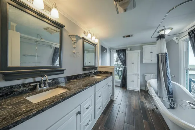 a bathroom with a granite countertop double vanity sink and a large mirror