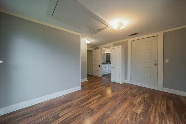a view of a big room with wooden floor and a kitchen