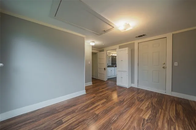 a view of a big room with wooden floor and a kitchen