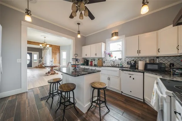 a kitchen with stainless steel appliances a table chairs refrigerator and cabinets