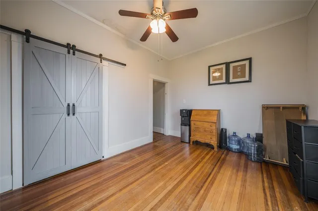 a view of a livingroom with wooden floor and a ceiling fan