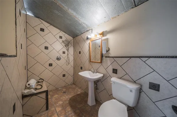 a bathroom with a toilet sink and shower curtain