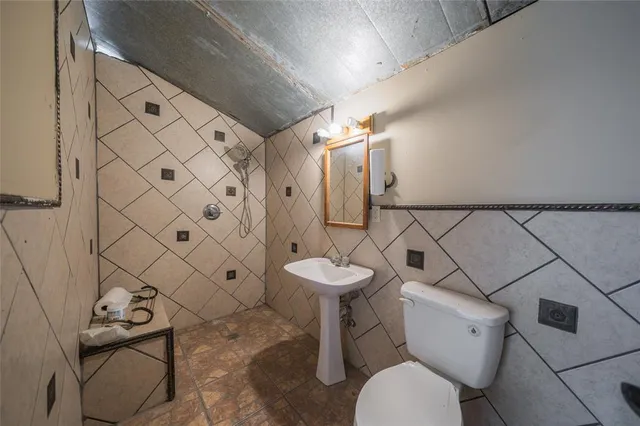a bathroom with a toilet sink and shower curtain