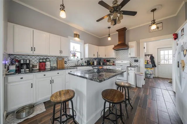 a kitchen with stainless steel appliances granite countertop wooden cabinets a dining table and chairs