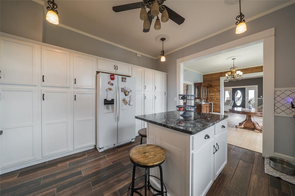 101 South Jacob Lane Winters, TX 79567 - Photo 4 of 38 a kitchen with stainless steel appliances granite countertop a refrigerator a sink dishwasher a dining table and chairs with wooden floor