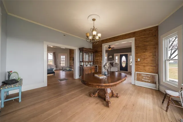 a dining room with wooden floor and a chandelier