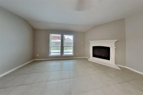 a view of an empty room with a fireplace and a window