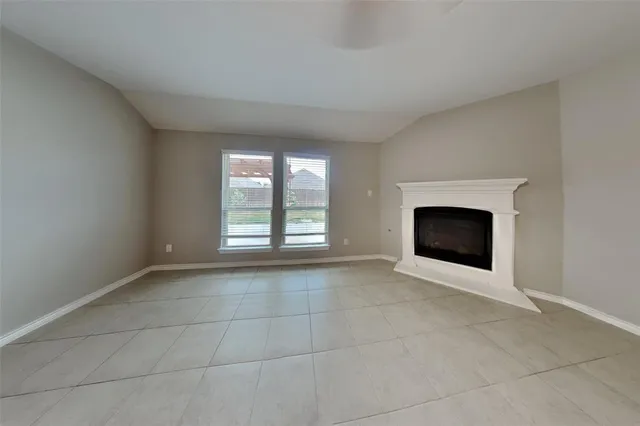 a view of an empty room with a fireplace and a window
