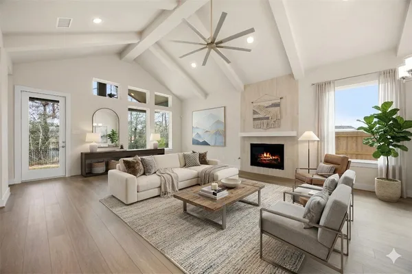 a living room with furniture a fireplace and a large window with wooden floor