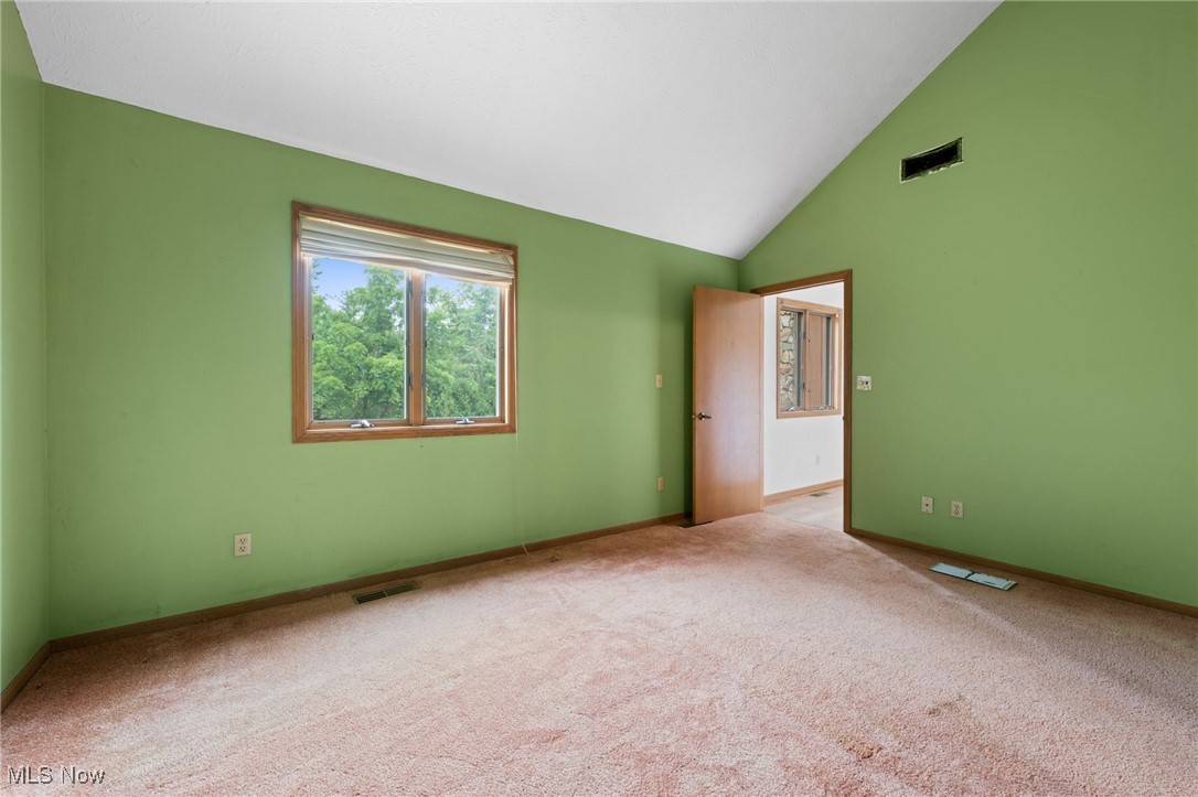 163 Burns Road Elyria, OH 44035 - Photo 15 of 37 Carpeted primary bedroom with high vaulted ceiling and baseboards