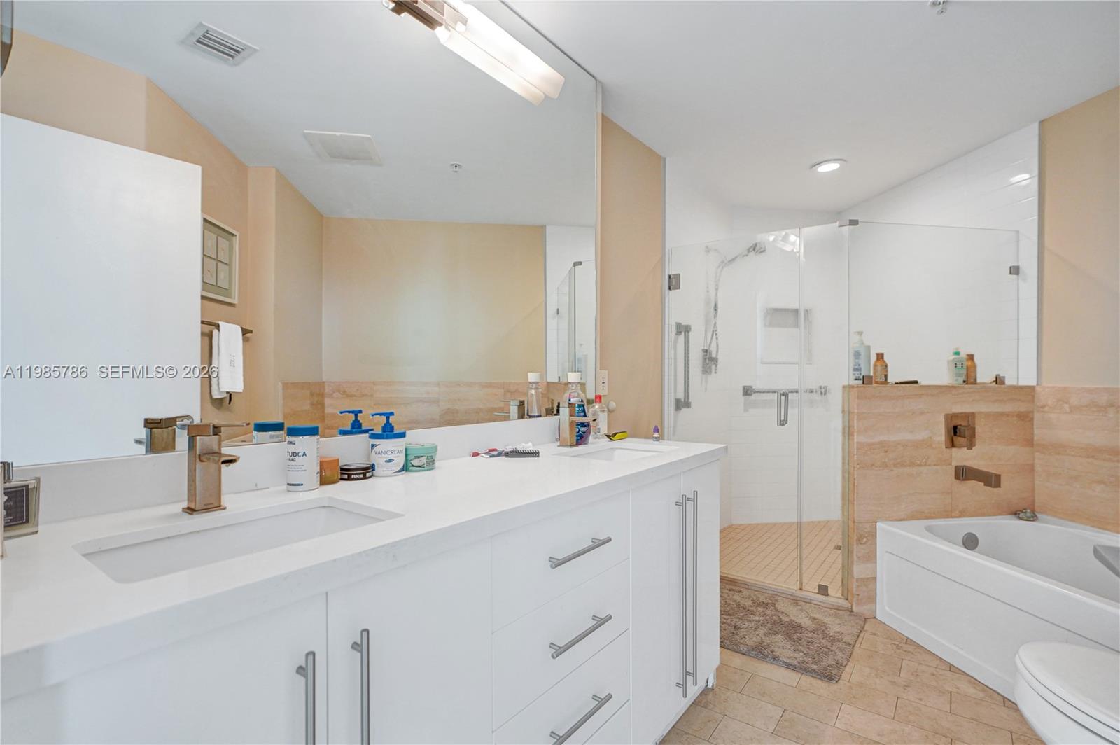 79 Southwest 12th Street, Unit 3412S Miami, FL 33130 - Photo 15 of 37 a bathroom with a double vanity sink a mirror and a bathtub