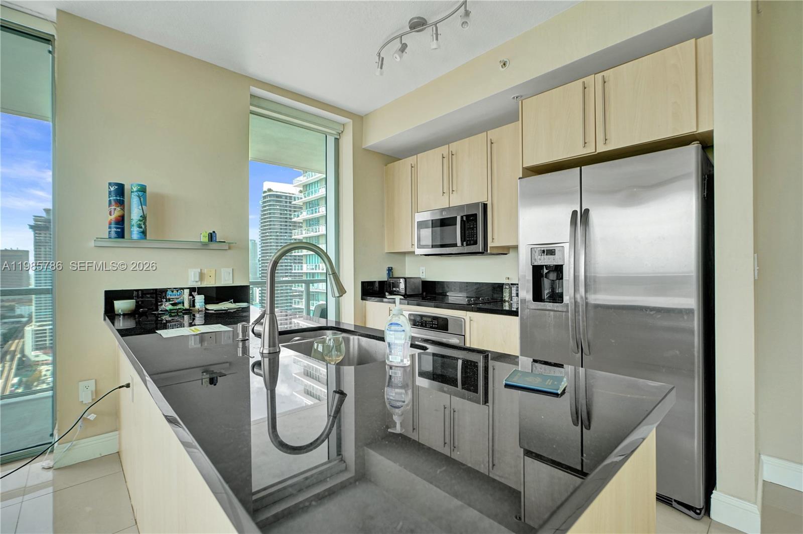 79 Southwest 12th Street, Unit 3412S Miami, FL 33130 - Photo 9 of 37 a kitchen with stainless steel appliances granite countertop a refrigerator a stove and a sink with large window