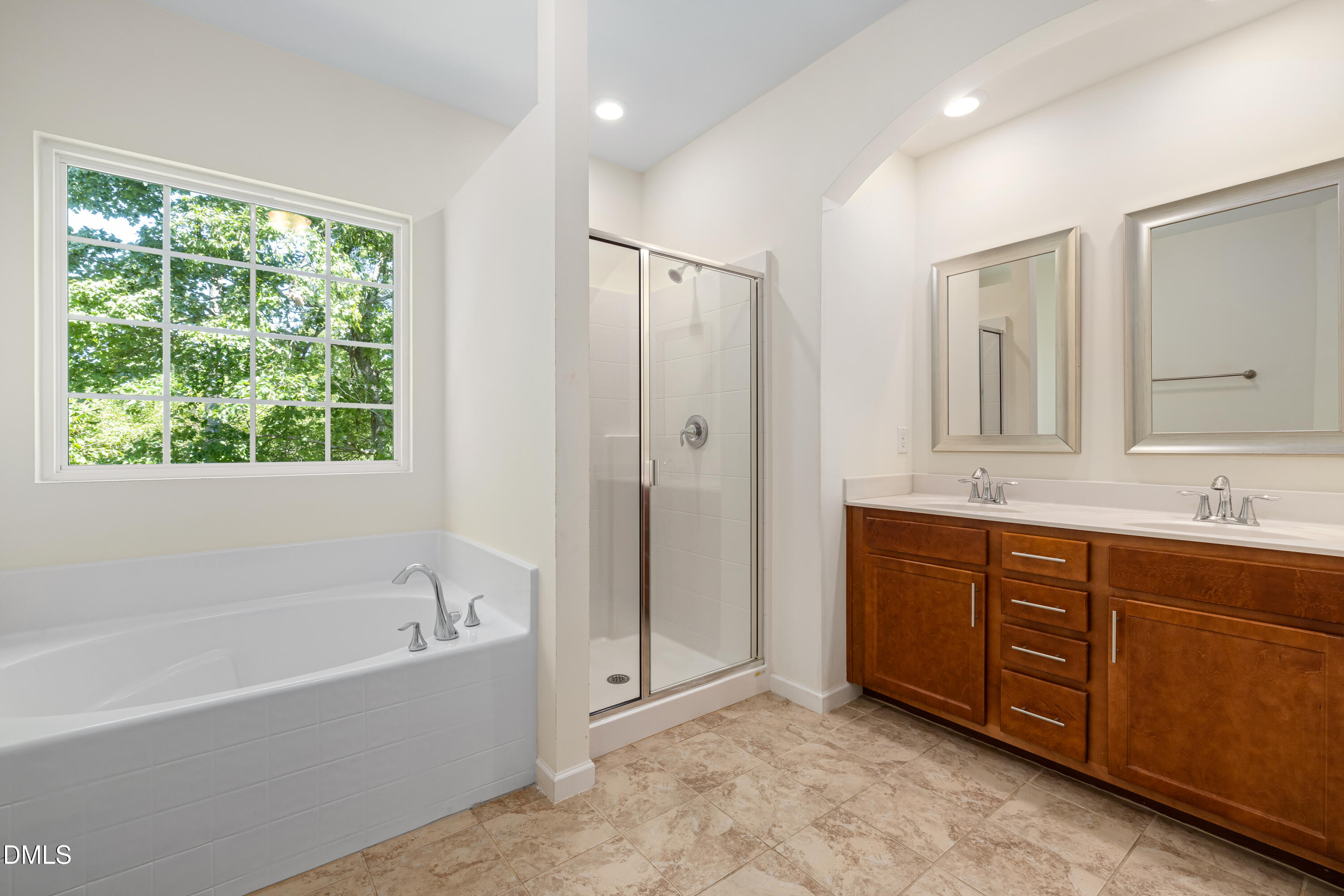 4351 Flintlock Lane Durham, NC 27704 - Photo 25 of 29 a spacious bathroom with a tub sink shower and mirror