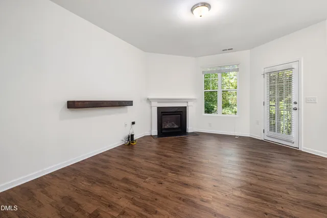 an empty room with wooden floor and a window
