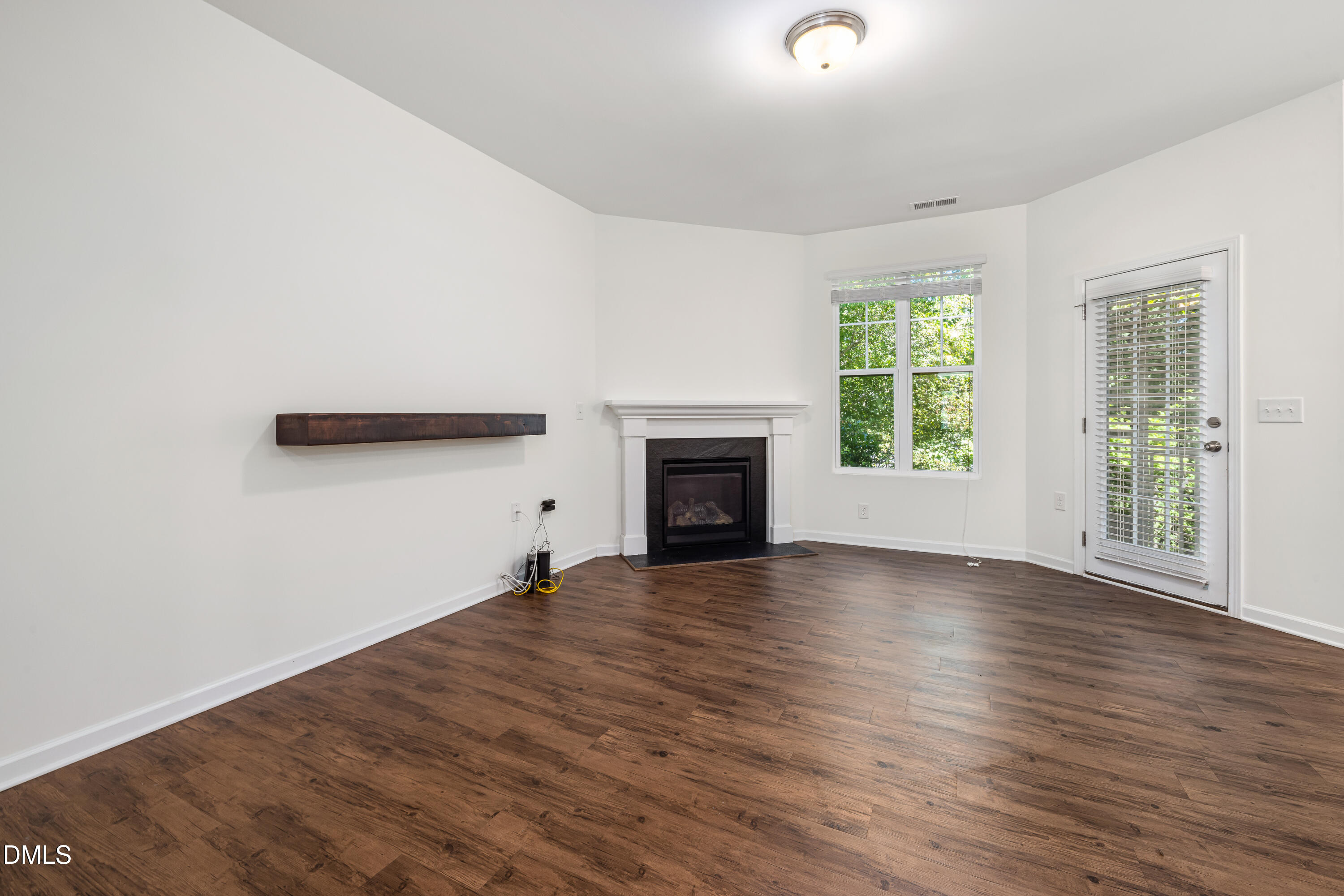 4351 Flintlock Lane Durham, NC 27704 - Photo 6 of 29 an empty room with wooden floor and a window