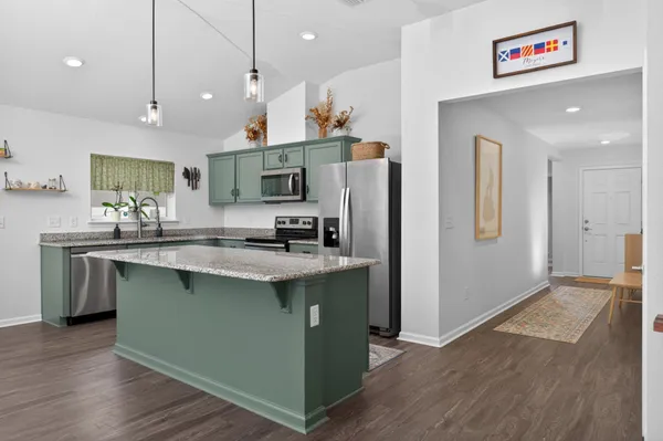 a kitchen with stainless steel appliances granite countertop a refrigerator a sink and a stove