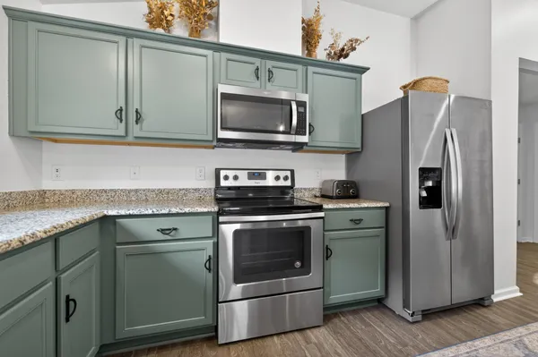 a kitchen with stainless steel appliances granite countertop a refrigerator stove and microwave