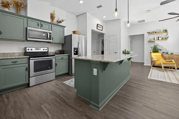 a kitchen with stainless steel appliances granite countertop a stove a sink dishwasher and a refrigerator