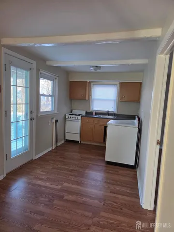 a view of a kitchen with a sink stove cabinets and empty room