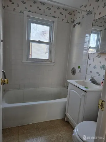 a white bath tub sitting next to a toilet