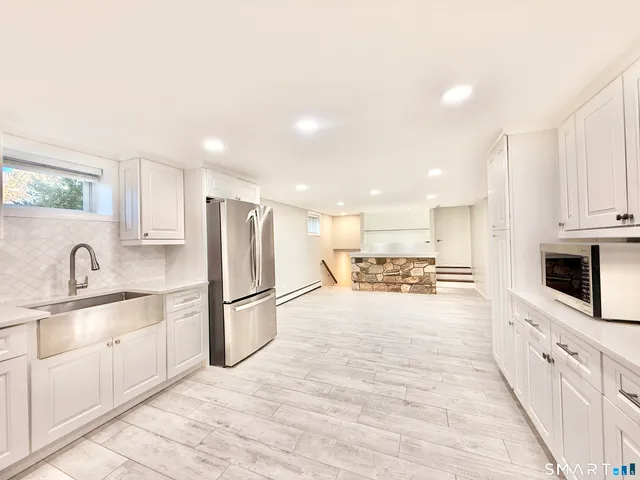 a view of empty room with a kitchen and a sink