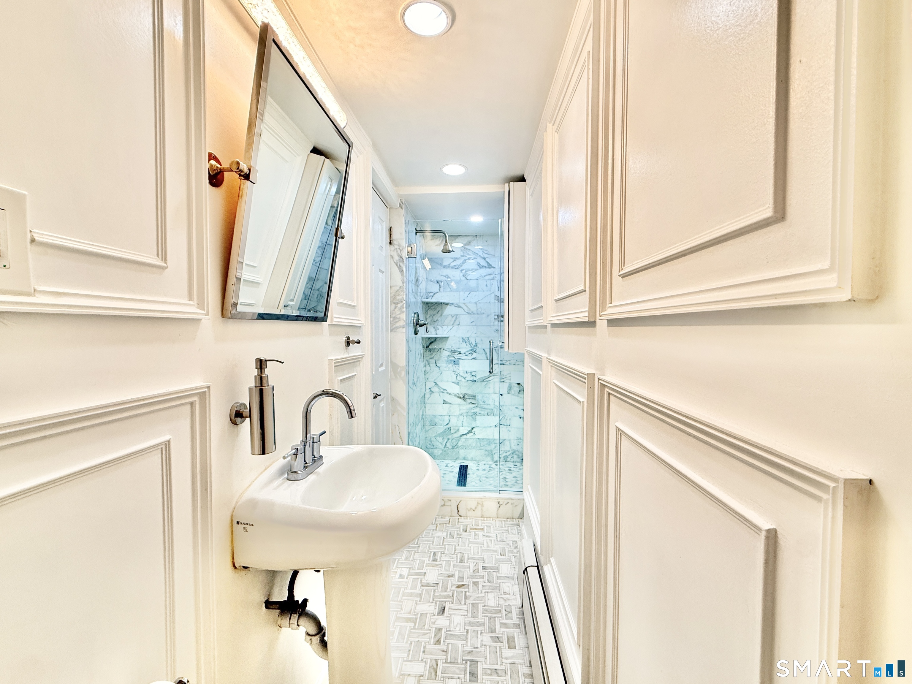 36 Center Drive Greenwich, CT 06870 - Photo 21 of 30 a bathroom with a sink a mirror and a shower