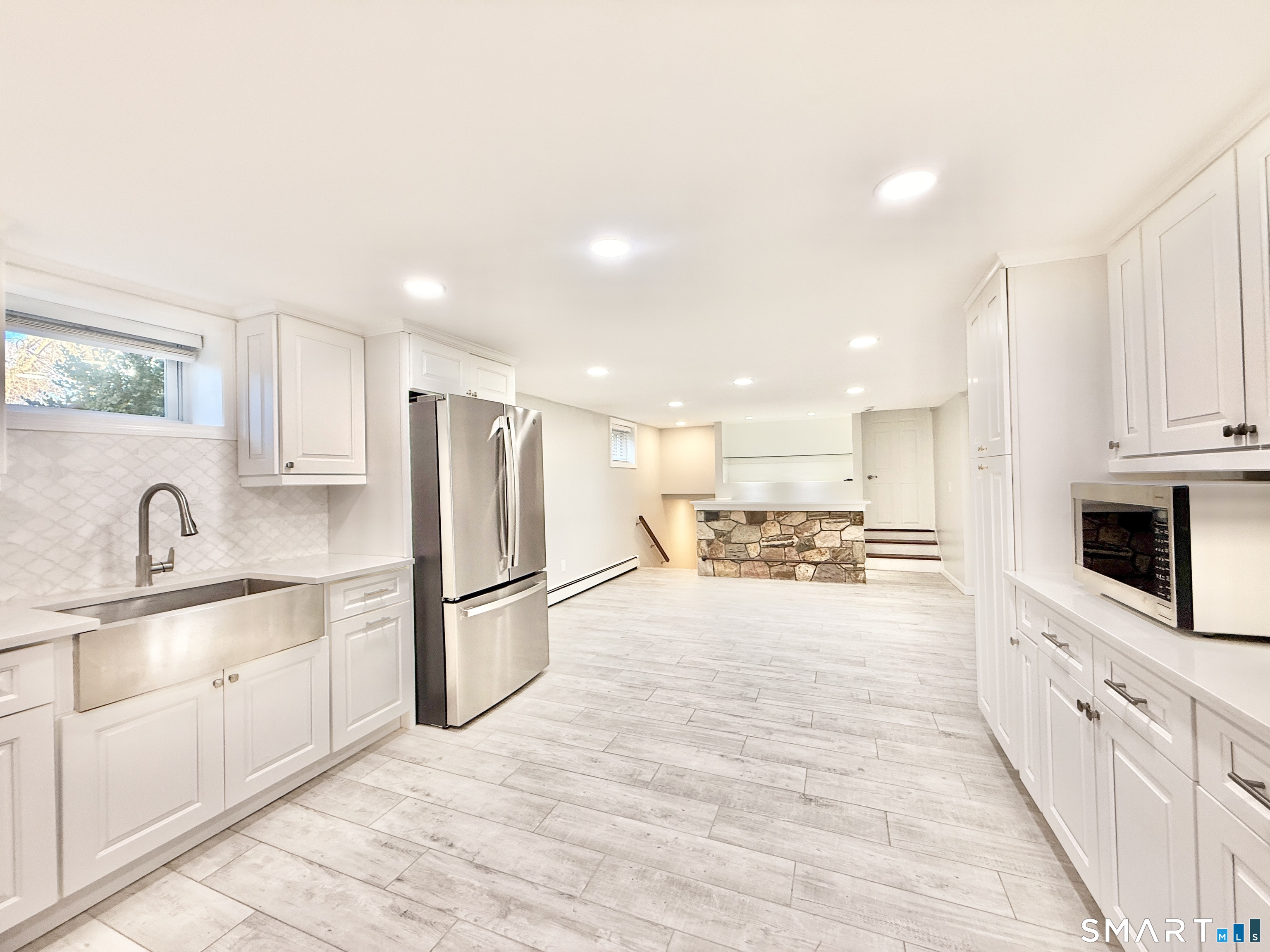 36 Center Drive Greenwich, CT 06870 - Photo 28 of 30 a large kitchen with stainless steel appliances kitchen island granite countertop a refrigerator oven a sink dishwasher and white cabinets with wooden floor