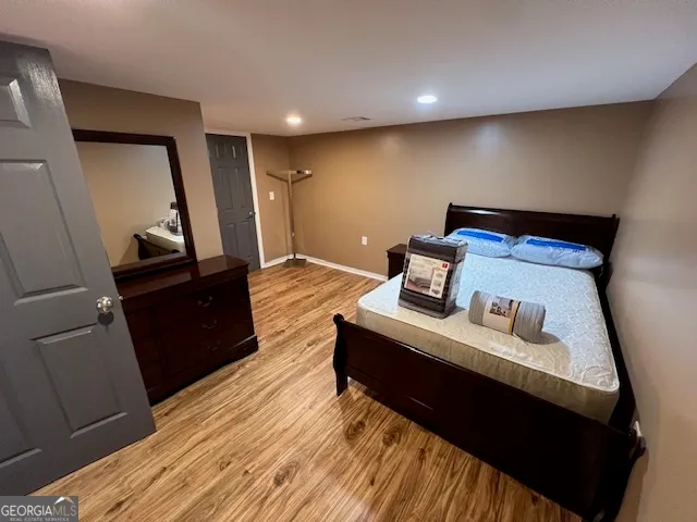 a bedroom with a bed and wooden floor