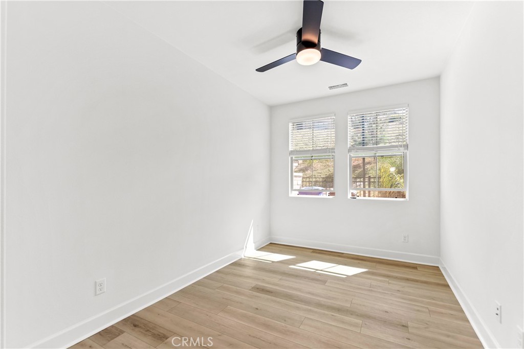 5024 Rexton Drive Camarillo, CA 93012 - Photo 19 of 48 an empty room with wooden floor chandelier fan and windows
