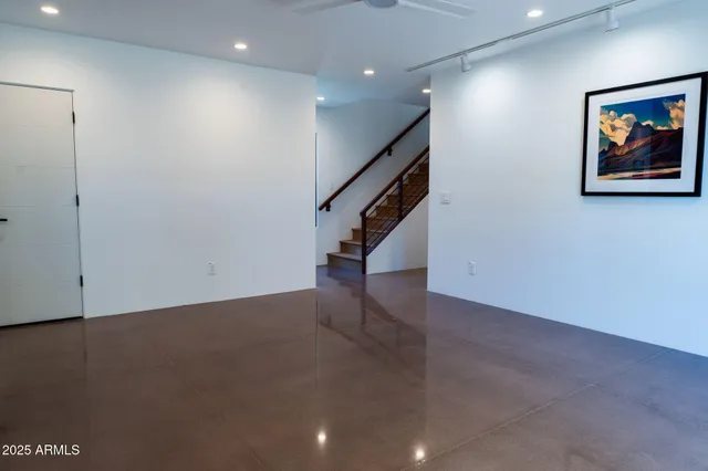 an empty room with stairs and wooden floor