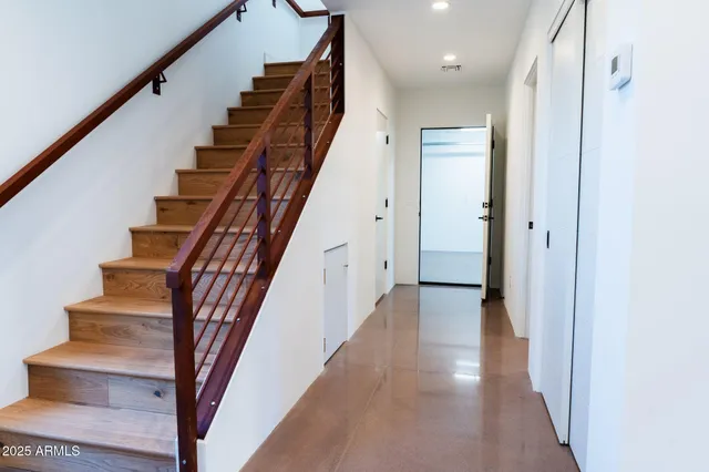 a view of staircase with lots of frames on wall and wooden floor
