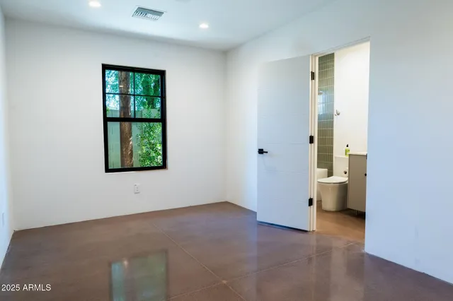 an empty room with windows and closet