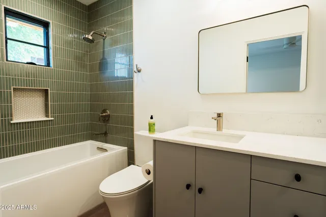 a bathroom with a sink toilet a mirror and bathtub