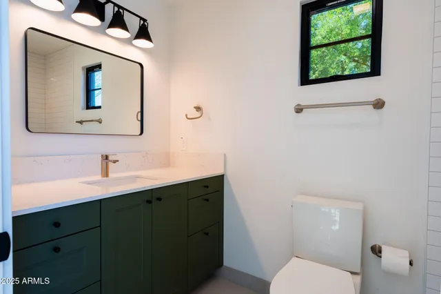 a bathroom with a toilet a sink and mirror