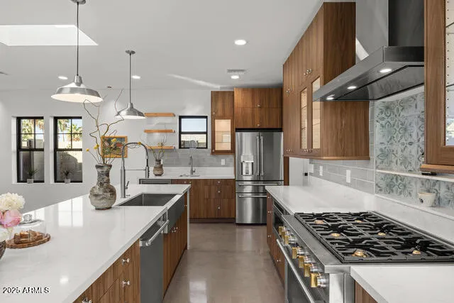 a kitchen with stainless steel appliances granite countertop a sink stove and refrigerator