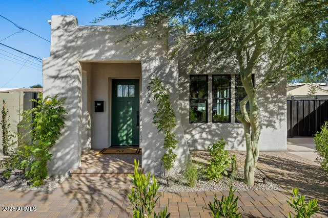 a front view of a house with a tree