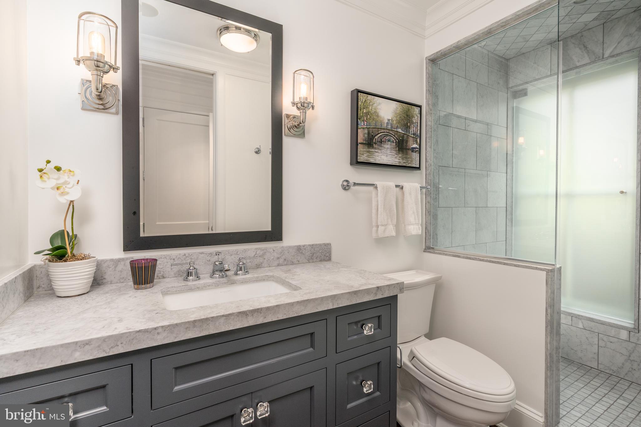 1619 19th Street Northwest Washington, DC 20009 - Photo 25 of 50 a bathroom with a granite countertop toilet sink and mirror
